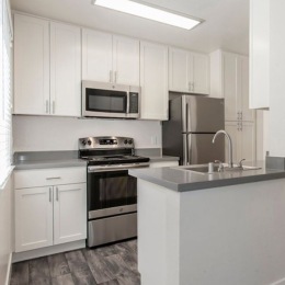 a kitchen with white cabinets and stainless steel appliances