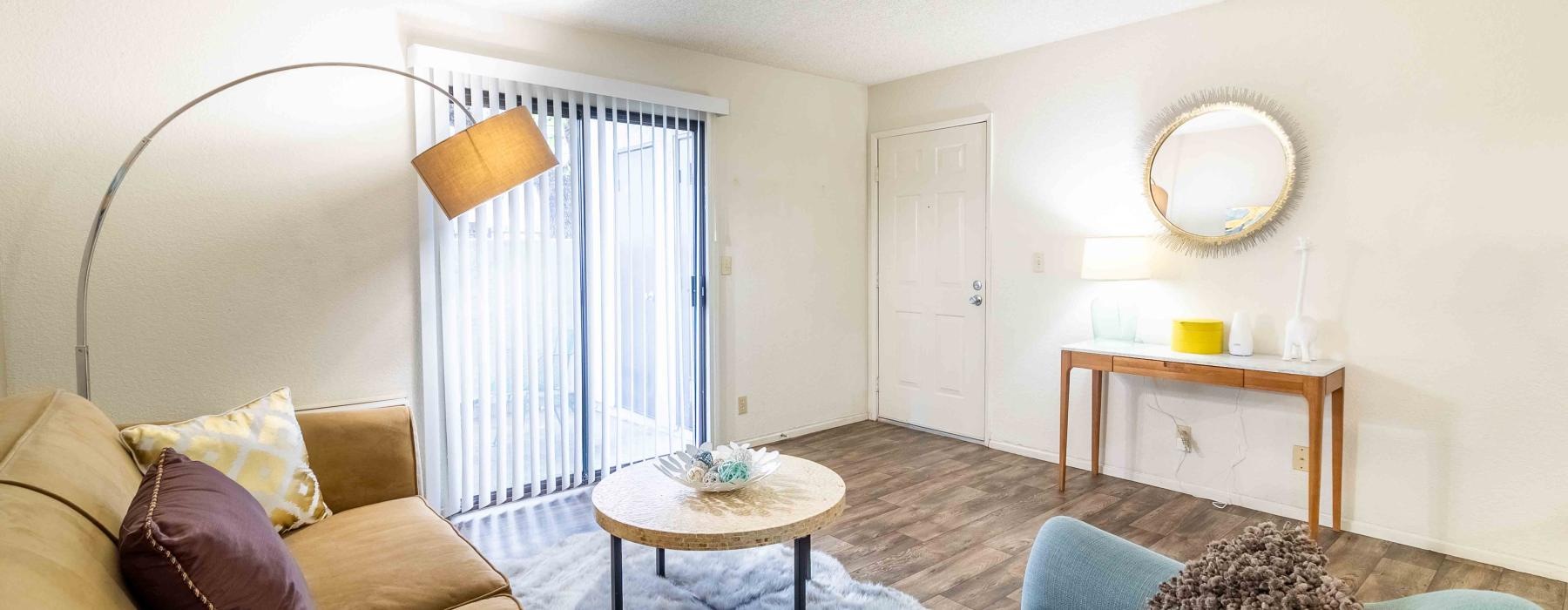 a living room with a lamp mirror  couch and a table